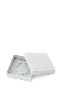 Bracelet en argent exposé à l'intérieur d'une boîte ouverte de couleur gris clair avec une finition texturée et un logo en relief ; présente des perles rondes et réfléchissantes.