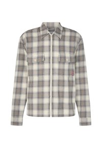 Camicia di flanella a plaid in tonalità crema, marrone e grigio. Presenta una chiusura con zip, due tasche sul petto e una texture morbida con colletto strutturato.