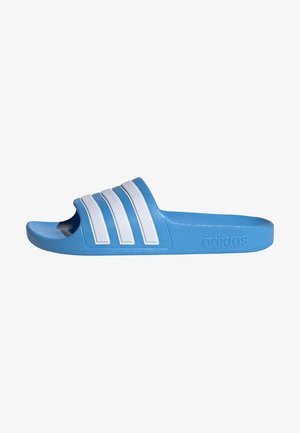 Blue slide sandal made of textured rubber, featuring three white stripes on the upper and an embossed logo on the side. Flat sole design.