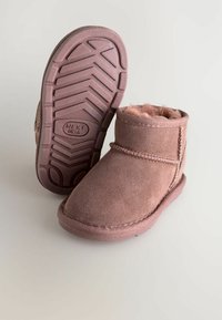 Rózsaszín velúr bokacsizma puha bélésborítással, gumitalppal, amelynek tread mintázata van, és dísztűzéssel a felső széle mentén.
