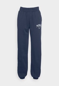 Mörkblå sweatpants med resår i midjan och vid cuffarna, prydda med en vit Nike-logotyp på vänster l år. Tillverkade av ett mjukt, stretchigt material.