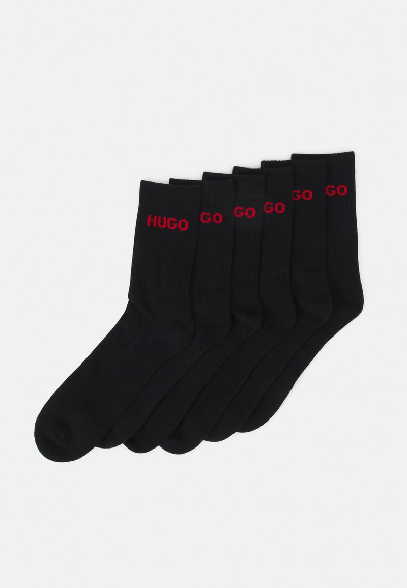 Des chaussettes en coton noires en pack de six, présentant une texture côtelée avec "HUGO" et "GO" imprimés en rouge sur la zone de la cheville.