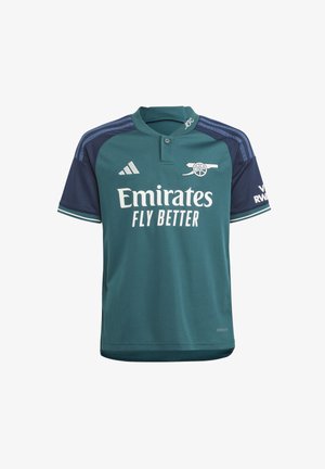 Jersey deportivo color verde azulado con mangas y cuello navy, y texto blanco que dice "Emirates Fly Better." Presenta un logotipo bordado y acentos a rayas.
