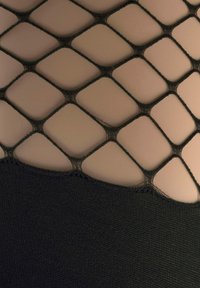 Schwarzes Netzmaterial mit rautenförmigen Öffnungen über einem soliden schwarzen Stoffbereich, der den Kontrast von Textur und Muster zeigt.