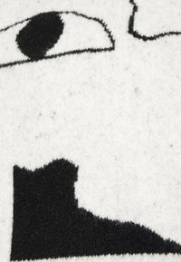 Wollmischgewebe mit einem weißen Hintergrund und schwarzen abstrakten Formen, darunter ein Augendesign und gezackte Akzente, weiche Textur.