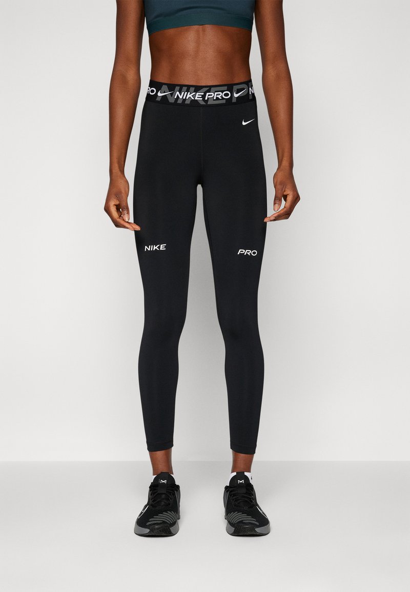 Leggings neri realizzati in un tessuto elasticizzato con una vestibilità aderente. Presentano una cintura ampia con il marchio "NIKE PRO" e dettagli in bianco del logo.