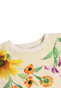 Kremveida blūze ar spilgtām saulespuķēm un oranžsarkaniem ziediem ap traipiem un zaļām lapām ap apkakli uz baltas fona.