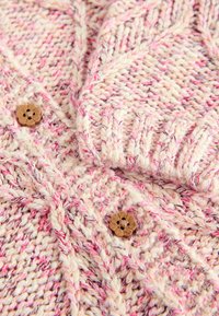 Gebreide cardigan in crèmekleurige en roze tinten, met een gestructureerd patroon, geribde mouwen en houten knopen in de vorm van bloemen.