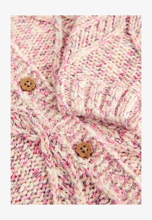 Adītas kardigānas krēma un rozā toņos, ar teksturētu rakstu, ribotām piedurknēm un koka zieda formas pogām.