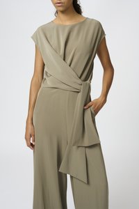 Olive green jumpsuit in lightweight fabric, featuring a wrap design with a tied sash at the waist and short sleeves, minimalistic construction.