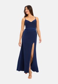 Granatowa maxi sukienka wykonana z gładkiego materiału, z dekoltem w kształcie serca, cienkimi ramiączkami i rozcięciem sięgającym do uda.