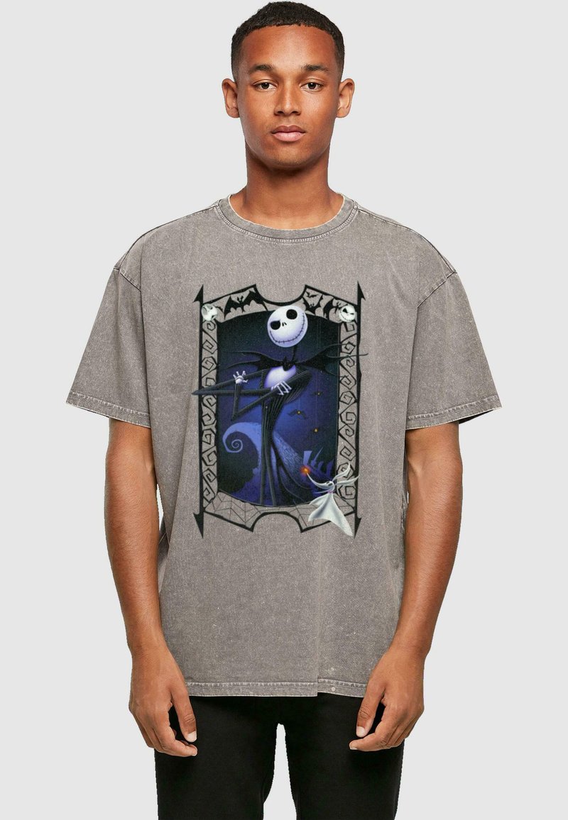 T-shirt gris surdimensionné présentant un graphisme de Jack Skellington, avec une finition texturée et un contour noir, sur un fond multicolore.