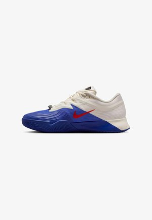 Scarpe sportive con un design blu e bianco e il logo Nike rosso. La parte superiore è testurizzata e la suola ha un battistrada a motivo per la trazione.