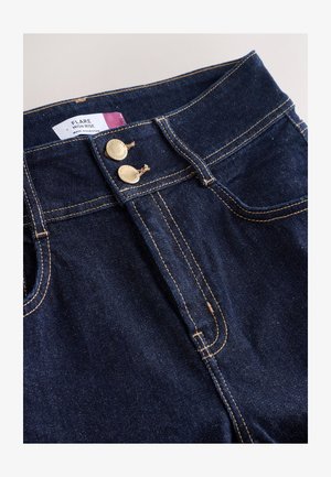 Jeans acampanados de tiro alto en denim azul oscuro, con botones de tono dorado, costuras visibles y diseño de cinco bolsillos.