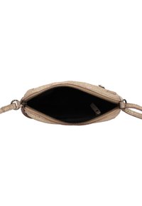 Mala bež crossbody s patentnim zatvaračem otvorenom da pokaže crni unutarnji dio i podešavajuće prstenove za remen s obje strane.
