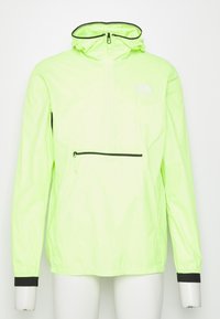 Chaqueta ligera, de color verde neón, con detalles en negro. Cuenta con un bolsillo frontal con cremallera y capucha ajustable. Fabricada con un material suave y resistente al agua.