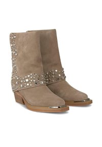 Botas de tobillo de ante beige con puntas redondeadas, decoradas con tachuelas plateadas y un acento plateado en la punta. Tacón apilado con aspecto de madera.