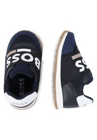Scarpe sportive navy realizzate con materiali in rete e pelle, dotate di una larga fascia nera con il marchio "BOSS" in bianco e dettagli beige. Suola in gomma.