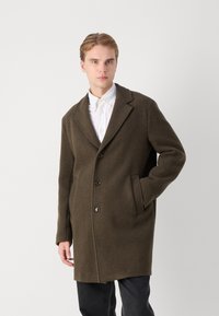 Mörk olivgrön yllekappa med spetsig krage, enfaldig design, tre knappar, sidofickor och en avslappnad passform.