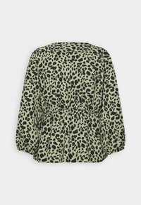 Blouse verte à motif noir tacheté, avec une taille peplum et des manches longues légèrement bouffantes. Tissu doux et coupe décontractée.