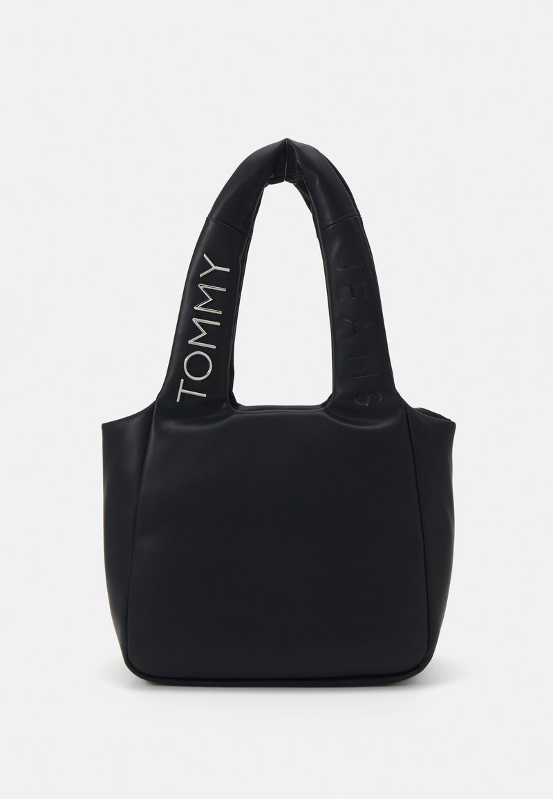 Sac à main noir matelassé avec deux grandes anses, avec le texte "Tommy Jeans" embossé et imprimé sur les anses.