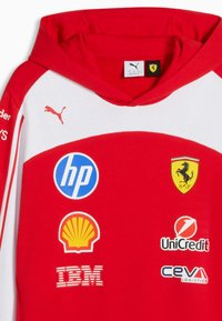 Sweat à capuche de course Ferrari rouge et blanc avec le logo Puma et les sponsors HP, Shell, IBM, UniCredit et CEVA Logistics sur le devant.