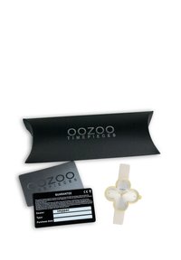 Montre Oozoo Timepieces avec un boîtier en forme de fleur en ton or, un bracelet en silicone blanc et un cadran minimaliste. Comprend un emballage et des cartes de garantie.
