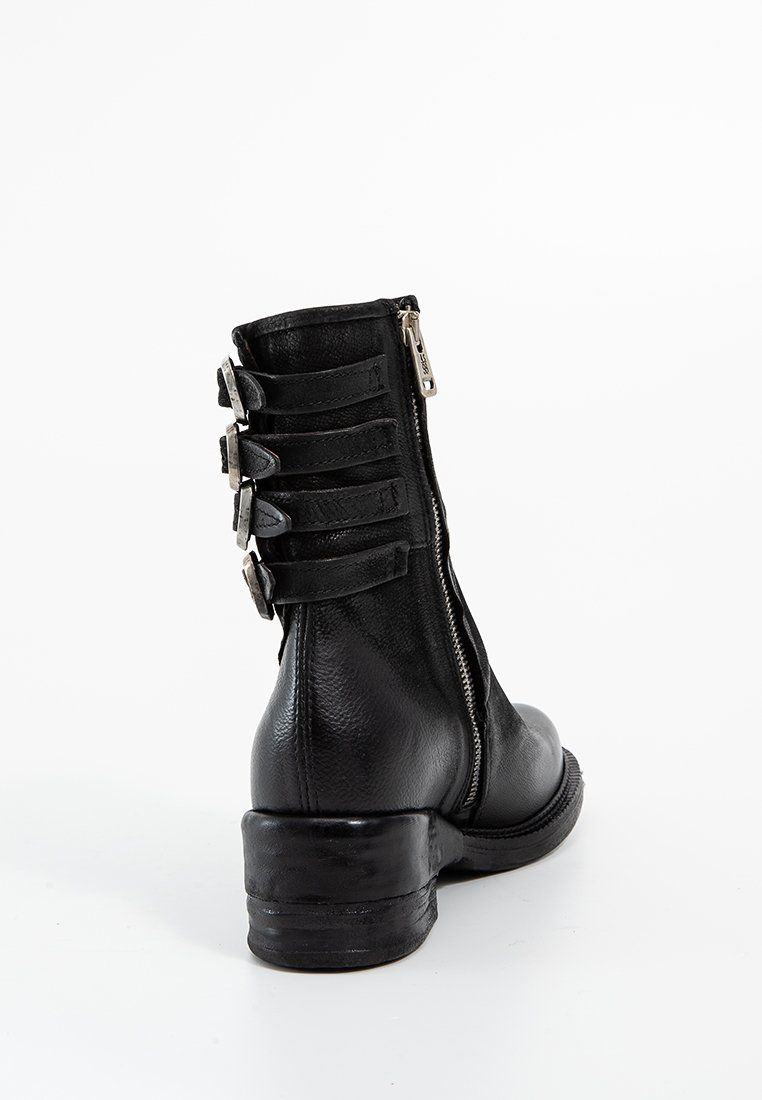 Bottine en cuir noir avec fermeture à glissière, accents de sangle horizontale à l'arrière et un petit talon empilé. Surface texturée.