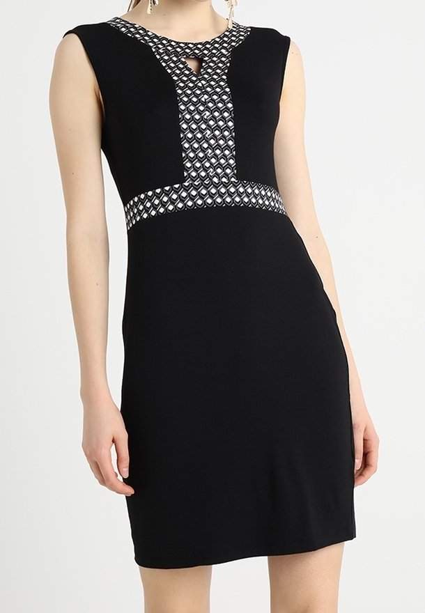Robe noire sans manches avec des détails géométriques noirs et blancs au niveau de l'encolure, de la taille et de l’ouverture poitrine.