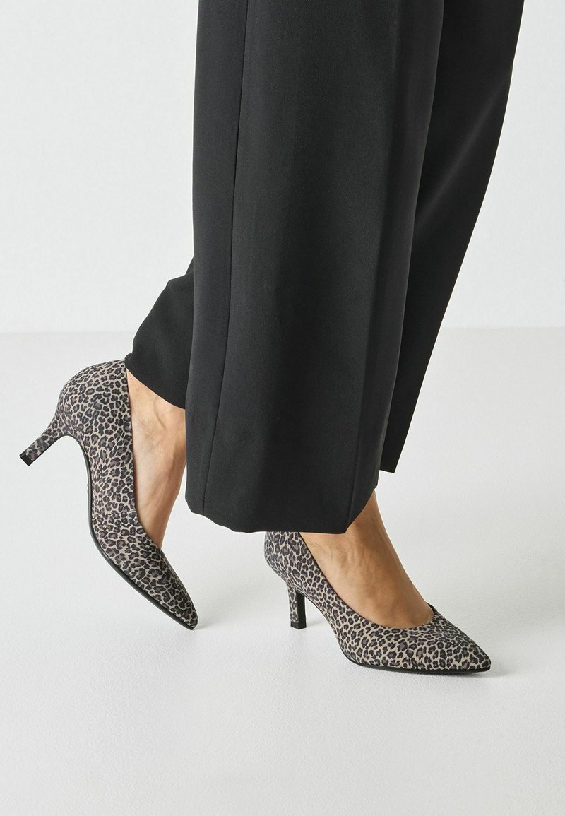 Escarpins à talons hauts imprimé léopard avec un bout pointu et un talon aiguille fin, présentant un tissu texturé aux nuances de beige et noir.