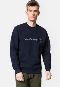 Granatowy sweter z bawełny, z okrągłym dekoltem i ściągaczami. Logo "LANĈERTO" w białym i czarnym kolorze z przodu.