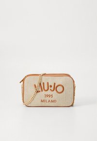 Sac en tissu crème avec accents en cuir orange. Dispose d'une bandoulière chaîne et du nom de la marque "LIU JO 1995 MILANO" affiché en évidence.