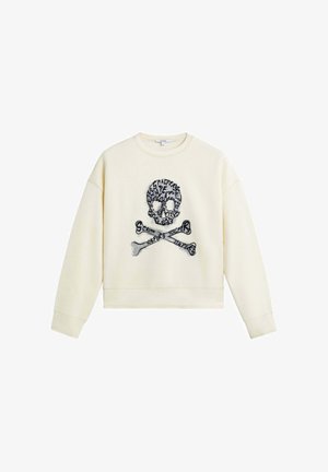 Hanorac de culoare crem, cu un design scurt, având o grafică brodată cu o cranio și oase încrucișate în centru. Textură de țesătură moale.