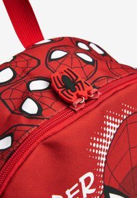 Roter Rucksack mit Spider-Man-Design. Strukturierter Stoff, ausgeprägter Spider-Logo-Reißverschluss und charakteristisches Netzmuster.