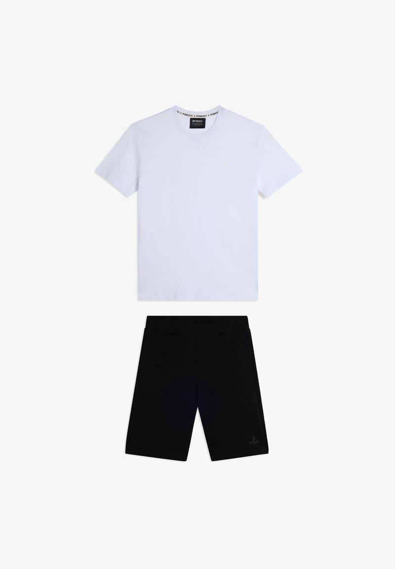 Camiseta blanca de manga corta y escote en V combinada con pantalones cortos negros hasta la rodilla. La camiseta tiene una etiqueta con el logotipo y los pantalones cortos cuentan con un cinturón elástico.