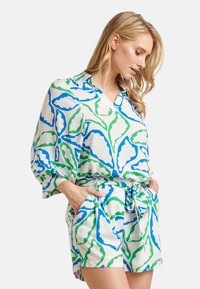 Korte mouwen, shirt met kraag en bijpassende short in het wit met groene en blauwe abstracte bladdessins. Beschikt over een strikceintuur en zijzakken.