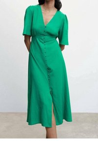 Robe verte à manches courtes bouffantes, décolleté en V, fente à l'avant et silhouette en A, fabriquée en tissu léger.