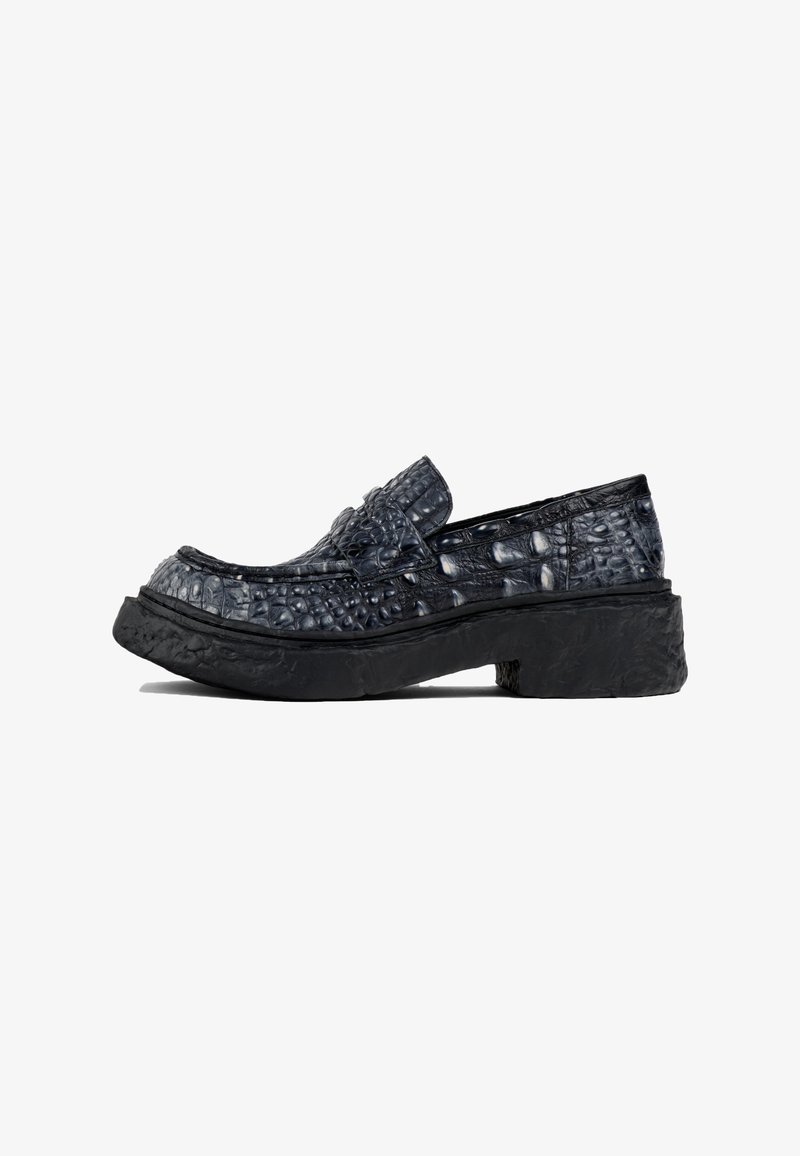 Mocasines de cuero negro texturizado con suela de plataforma, que presentan un brillante patrón de cocodrilo y un diseño de tipo slip-on.