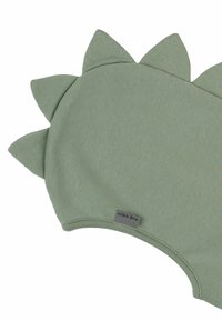 Groene stoffen zwemkleding met een gladde textuur, ronde vorm en rugvinnen langs de achterkant. Etiket zegt "mikk-line."