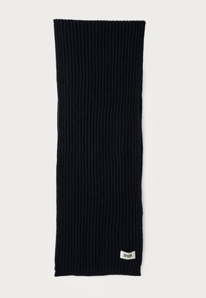 Écharpe en tricot côtelé bleu marine foncé avec une petite étiquette rectangulaire blanche "Drykorn" près d'une extrémité, posée à plat sur un fond blanc.