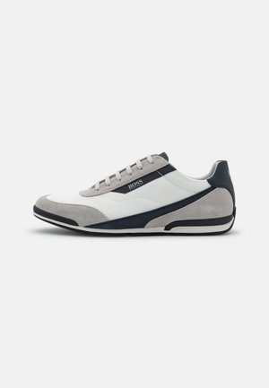 Lavprofileret afslappet sneaker i hvid mesh og gråt ruskind med navy detaljer, snørebånd og BOSS-logo på siden.