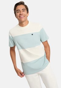 Camisa de manga corta en rayas azul claro y crema, con cuello redondo y un pequeño logo negro en el pecho. Hecha de mezcla de algodón.