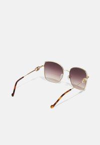 Gafas de sol cuadradas con lentes degradados, montura de metal dorado y puntas de acetato de carey. Detalle notable del logo en la montura.
