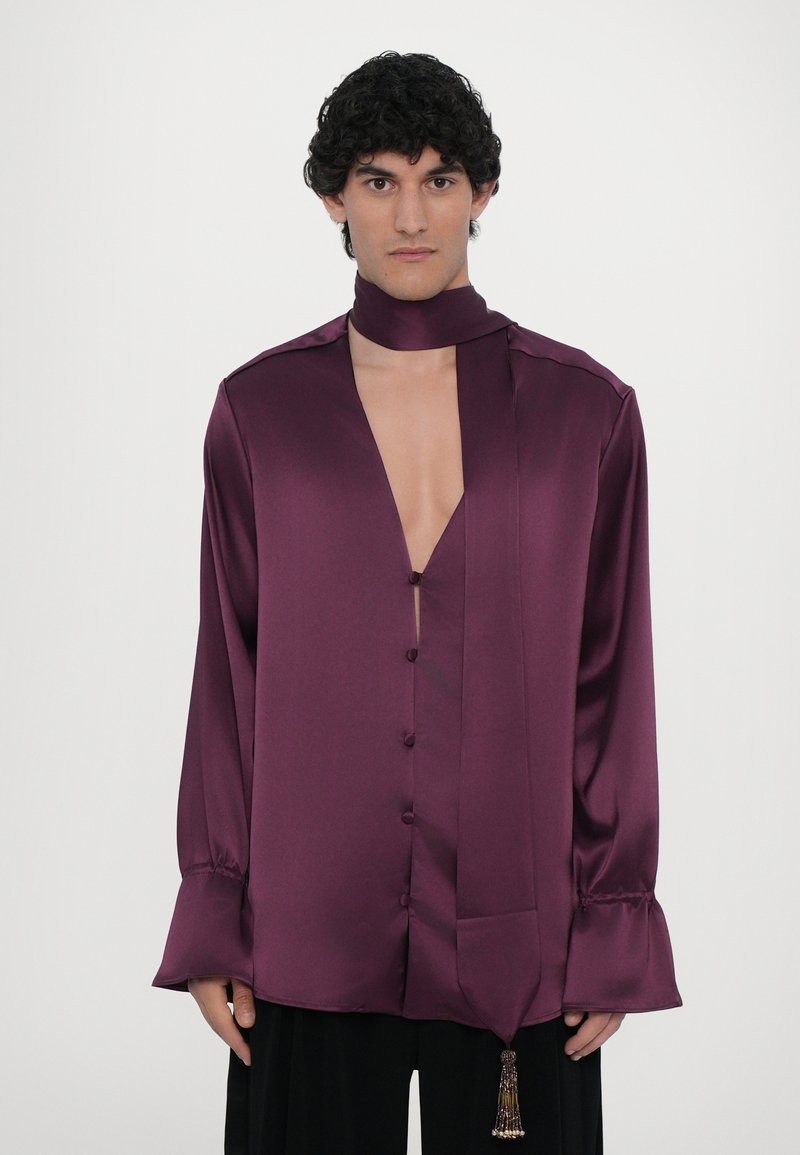 Long-sleeve, deep purple satin shirt with a plunging neckline, button front, and a matching neck tie featuring a decorative tassel.