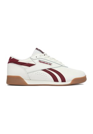 Witte low-top Reebok sneaker met kastanjebruine strepen, rubberen zool en Reebok-logo op de zijkant en tong.
