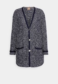 Granatowy kardigan z teksturowanym wzorem w cętki, długimi rękawami i dwoma przednimi kieszeniami. Posiada głęboki dekolt w serek i zapięcie na guziki.