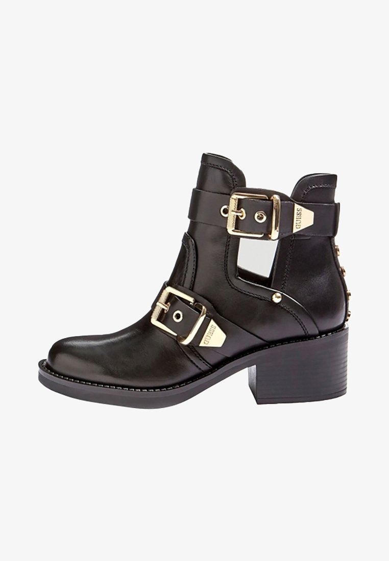 Bottine noire en cuir avec quincaillerie dorée, deux accents de boucles, tige texturée et talon bloc. Dispose d'un détail de découpe sur le côté.