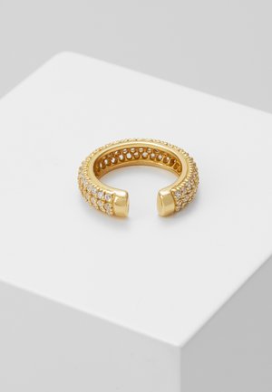 Guldtonet åben ring prydet med tre rækker af små klare krystaller, vist på en hvid overflade.