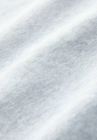 Tessuto di cotone azzurro chiaro con una consistenza morbida e liscia e sottili variazioni. La superficie mostra una leggera lucentezza alla luce.