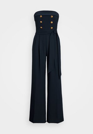 Navy strapless jumpsuit made of smooth fabric, featuring a fitted bodice, five gold buttons, wide-leg trousers, and a tied sash belt.